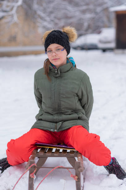 istock Girl On A Sled Playing In The Snow 1307535581