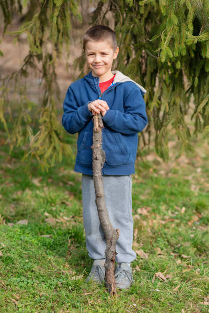 istock Little boy play with stick in forest 1307535851