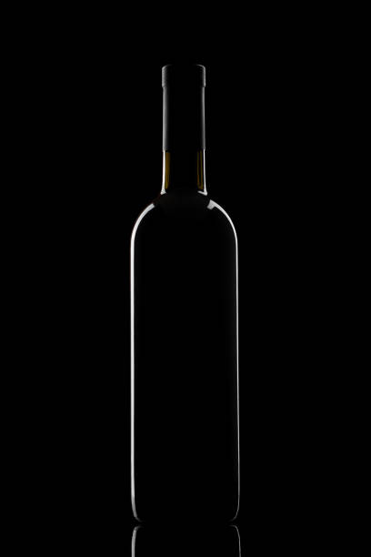 illuminated silhouette of a bottle with wine on a black background stock photo