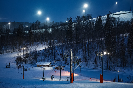 Russian snowy ski slope in evening lights