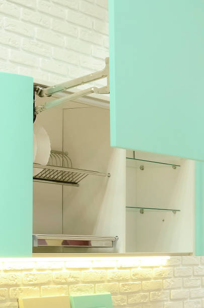 istock Kitchen front door lift pneumatic. Hardware for Kitchen Cabinets. green kitchen cupboard. Vertical photography. 1307539105