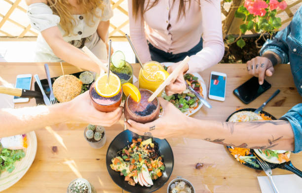 istock Happy friends cheering with fresh smoothies while lunching together - Young people having fun eating in coffee brunch vintage bar - Healthy food trends and youth lifestyle culture concept 1307539381