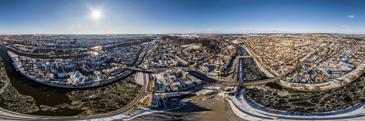 Panorama of Regensburg city in Bavaria with the river Danube the cathedral and the stone bridge in winter with ice and snow at sunset, Germany