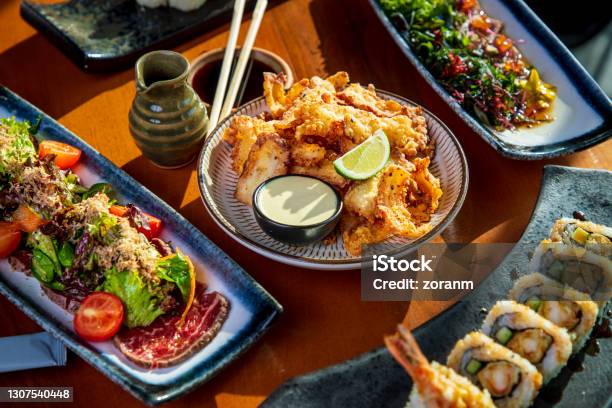 Tako Octopus Tempura On Restaurant Table Amid Other Japanese Cuisine Delicacies Stock Photo - Download Image Now