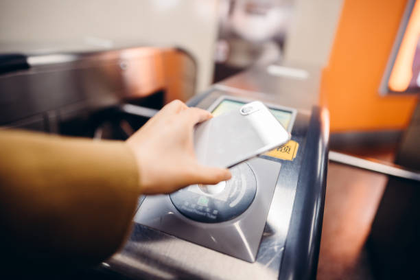 Using smart phone to pay at subway station. Asian businesswoman waiting for the subway train. Korea, Japan, China - East Asia, Singapore, Mobile Phone, Women, Smart Phone, contactless airport stock pictures, royalty-free photos & images