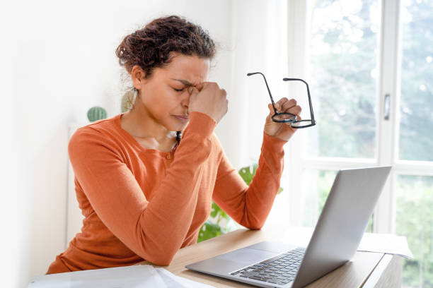 Woman feeling tired and overworked working from home Black woman is suffering eyestrain and headache effort stock pictures, royalty-free photos & images