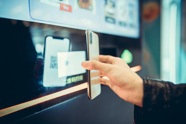 Using smart phone to pay at subway station. Asian businesswoman waiting for the subway train. Korea, Japan, China - East Asia, Singapore, Mobile Phone, Women, Smart Phone, contactless airport stock pictures, royalty-free photos & images