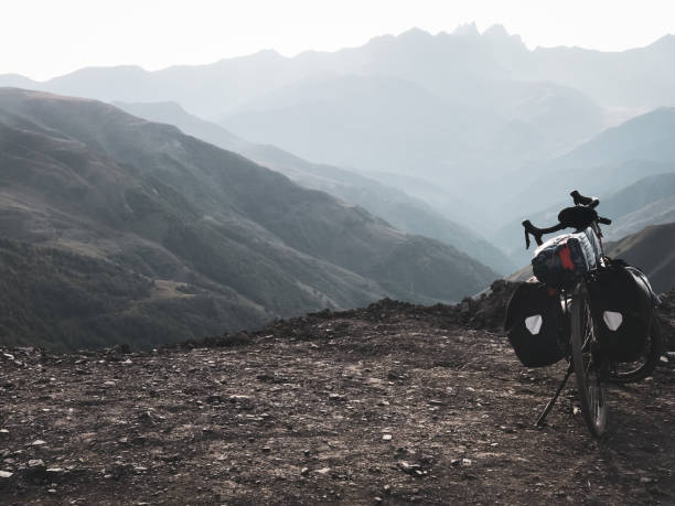 loaded touring bicycle stands with moody dramatic panoramic mountains view and no cyclist - tusheti imagens e fotografias de stock