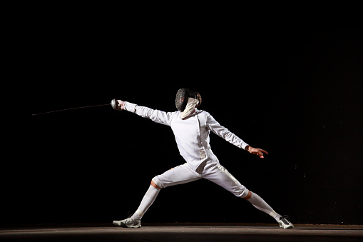 Fencing, exercise and people fight, jump and training, fitness or workout for energy with epee sword in club. Battle, fencer or athlete in performance, competition or sports with mask, helmet or suit