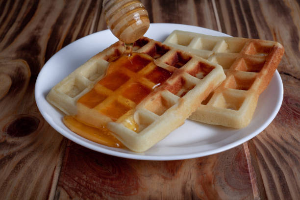 istock Honey pouring from dipper on Belgian waffles 1307541613