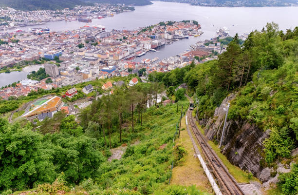 City of Bergen in Norway - aerial panorama view with the world famous cable car Fløibane driving to the summit Famous sightseeing spot in the city of Bergen, Norway, Scandinavia, cable car Fløibane driving goes to the summit with cityscape in background fløyen stock pictures, royalty-free photos & images