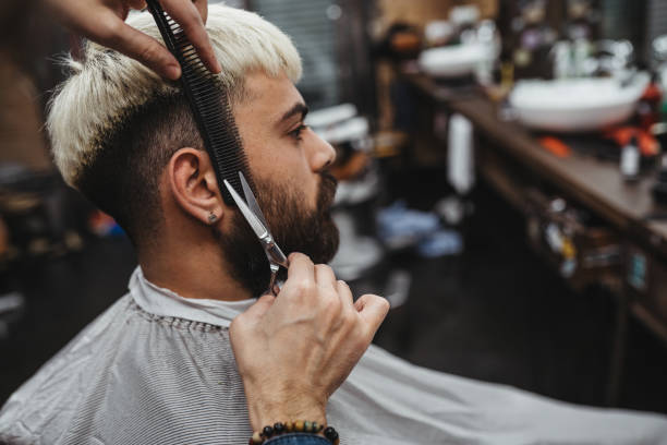istock Barber Giving A cut beard in His Shop 1307543449