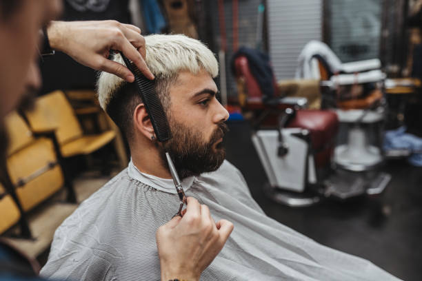 istock Barber Giving A cut beard in His Shop 1307543488