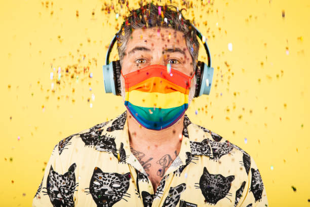 сумасшедший мужчина в маске празднует день гей-прайда на желтом фоне - gay pride flag audio стоковые фото и изображения