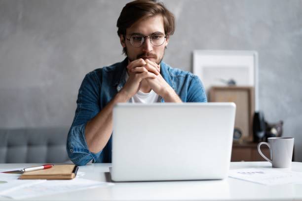 istock Thoughtful man looking away while sitting at his working place in office 1307544518