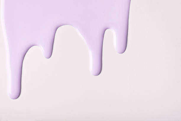 istock Lilac liquid drops of paint color flow down, isolated white background. Abstract purple backdrop with fluid drip pattern 1307544721