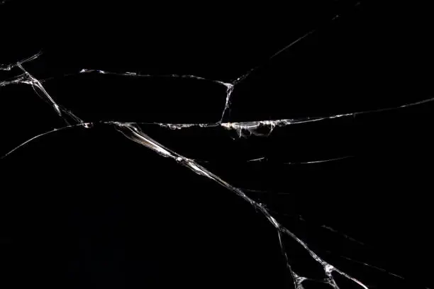 Cracked glass on a black background close up