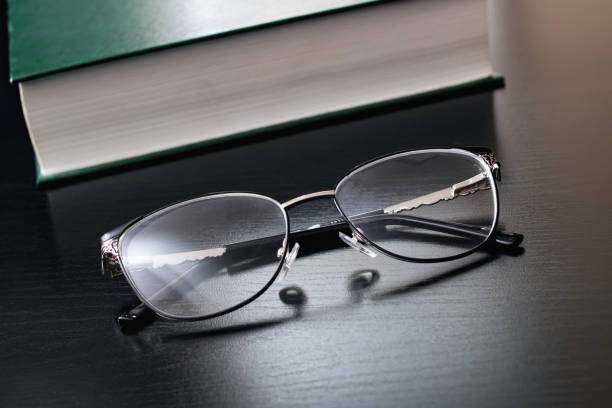 istock Glasses and green book on wooden table 1307548264