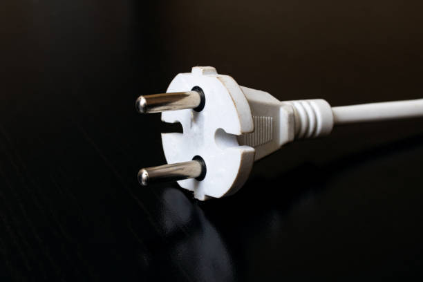 istock Electrical appliance plug on black wooden table 1307548504