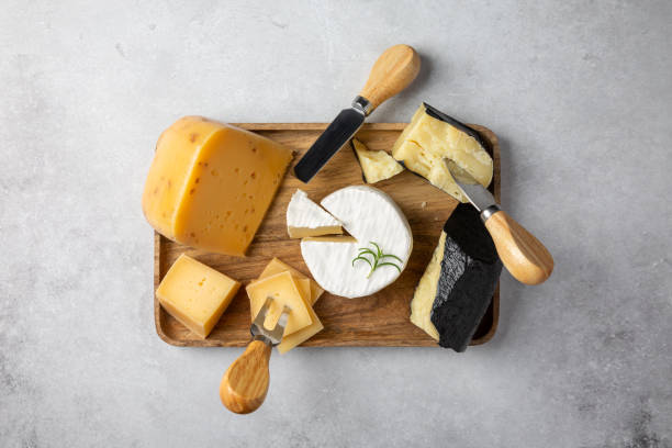 istock Cheese plate on gray table. Cheese platter on wooden board. Top view. 1307548839