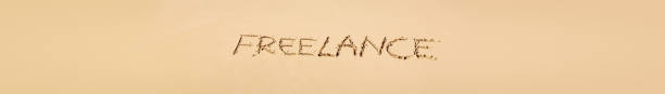 Word FREELANCE written on sand close to sea waves. Travel, business and  vacation concept background. Long banner