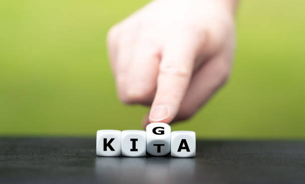 istock Hand turns dice and changes the German abbreviation KITA (daycare) to KIGA (Kindergarten). 1307550068