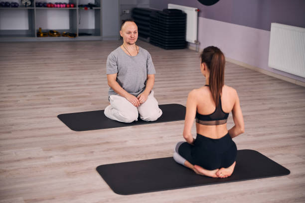 istock Delighted yoga tutor having practice with young woman 1307550199