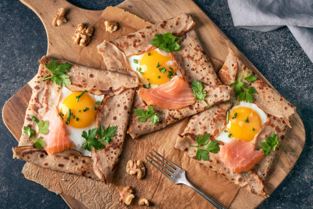 Crepes with eggs, salmon, spinach and nuts. Traditional dish galette sarrasin or buckwheat crepe, french brittany cuisine. Crepes with eggs, salmon, spinach and nuts. galette stock pictures, royalty-free photos & images