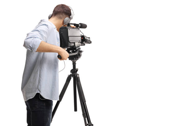 Rear shot of a cameraman recording with a professional camera on a stand Rear shot of a cameraman recording with a professional camera on a stand isolated on white background camera covers pictures stock pictures, royalty-free photos & images