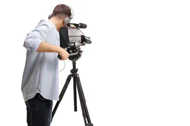 Rear shot of a cameraman recording with a professional camera on a stand isolated on white background
