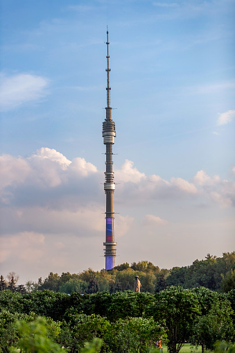 Ostankino TV tower rising in public park under the sky on a fine day