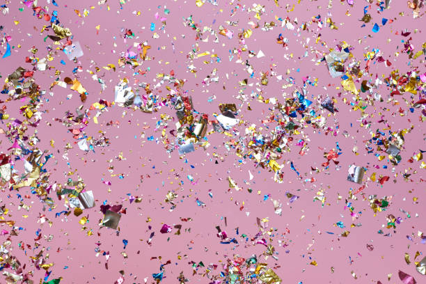istock Bright colorful confetti sparkles on a pink background. 1307552628