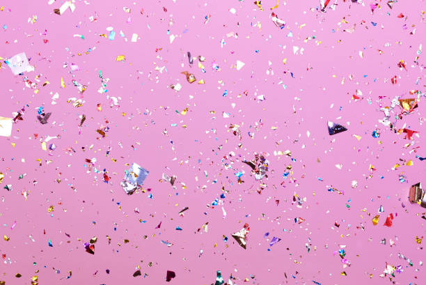Bright colorful confetti sparkles on a pink background.