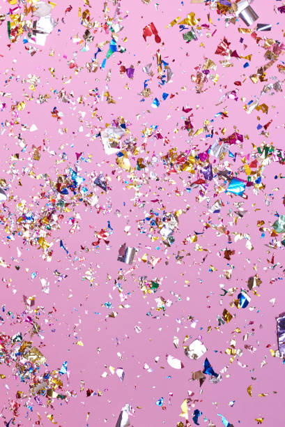 istock Bright colorful confetti sparkles on a pink background. 1307552677