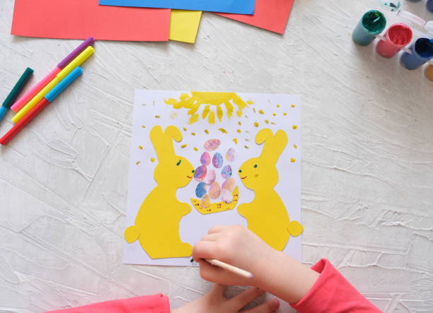 istock Child making card with Easter bunnies  from colorful paper. Applique. 1307553743