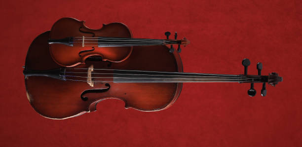 istock cello and violin on a red background 1307554844