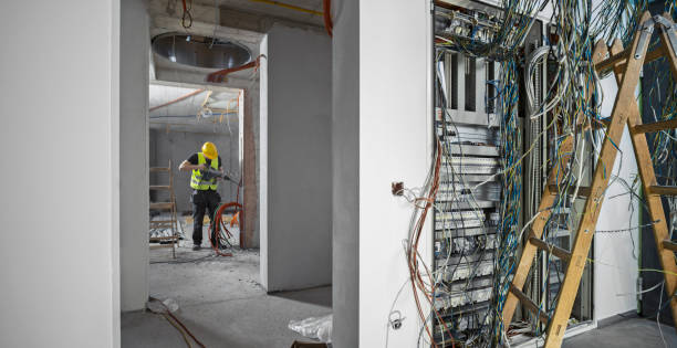 istock Electrician drilling wall at construction site 1307554867