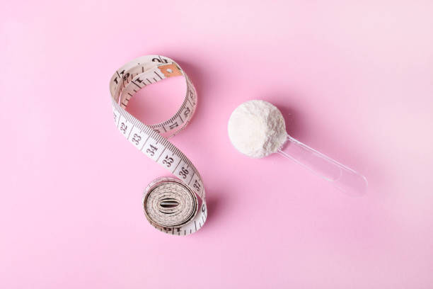 istock White protein powder in spoon and measuring tape 1307555317