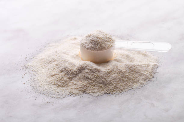 istock Heap of white protein powder with measuring spoon 1307555323
