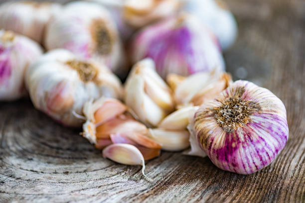 istock Garlic Cloves and Bulbs on Wooden Background 1307556473
