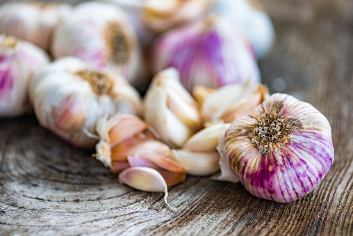 White and Pink Garlic Cloves on Wooden Background