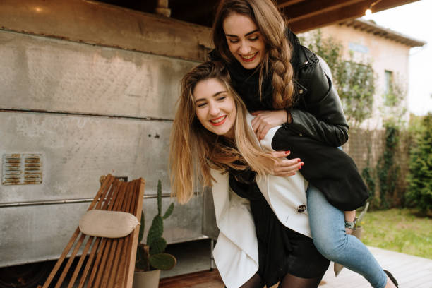 istock Two cheerful women walking piggyback 1307557727