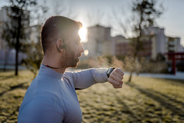 młody sportowiec sprawdzający bicie serca z inteligentnego zegarka po joggingu - breathing exercise jogging exercising relaxation exercise zdjęcia i obrazy z banku zdjęć