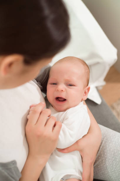 istock A small baby cries in her mother arms. 1307559192