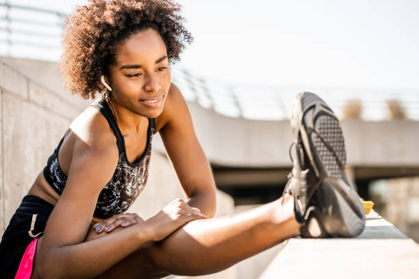 istock Afro athlete woman stretching legs before exercise. 1307560464