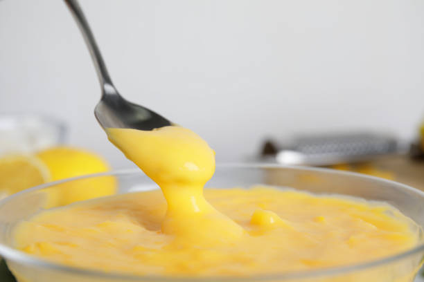 istock Spoon with delicious lemon curd above bowl, closeup 1307560700