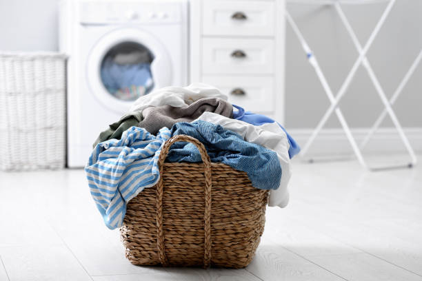 istock Wicker basket with dirty laundry on floor indoors 1307562793