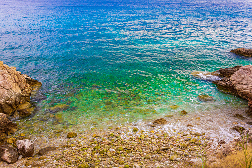 Wonderful turquoise and rocky beach and promenade in Novi Vinodolski Croatia.