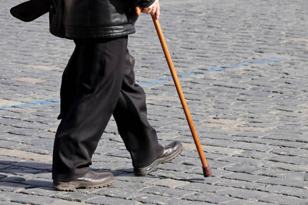 istock Man with walking cane on a street 1307565569