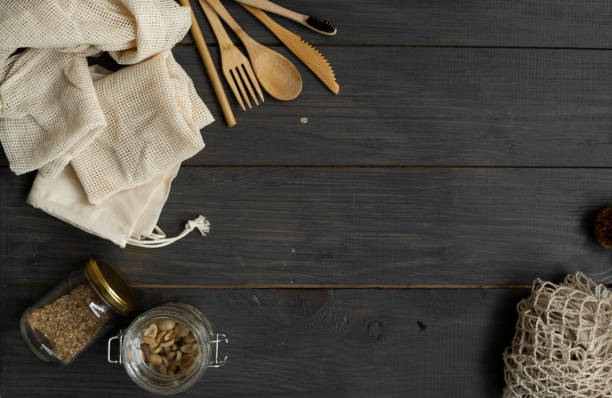 Zero waste kit. Set of eco friendly bamboo cutlery and cleaning brushes, mesh cotton bags, glass jars, loofah and bamboo toothbrushes. Natural and reusable items accessories on wood surface cero kit de residuos. conjunto de cubiertos de bambú ecológicos y cepillos de limpieza, bolsas de algodón de malla, tarros de vidrio, loofah y cepillos de dientes de bambú. accesorios de artículos naturales y reutilizables en superficie de madera.